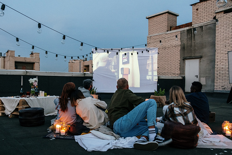 Groupe de personne regardant un film sur un toit d'immeuble