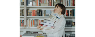 photo de femme portant des livres en pile dans une librairie