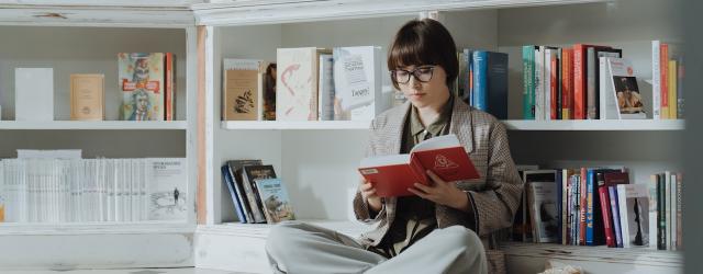 femme lisant un livre dans une librairie