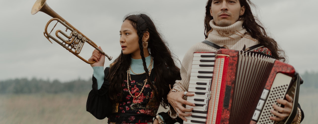 femme et homme dans un champs avec des instruments de musique