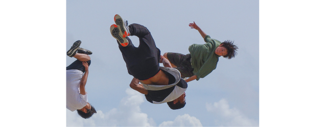 photo de jeunes réalisant des acrobaties sur fond de ciel bleu